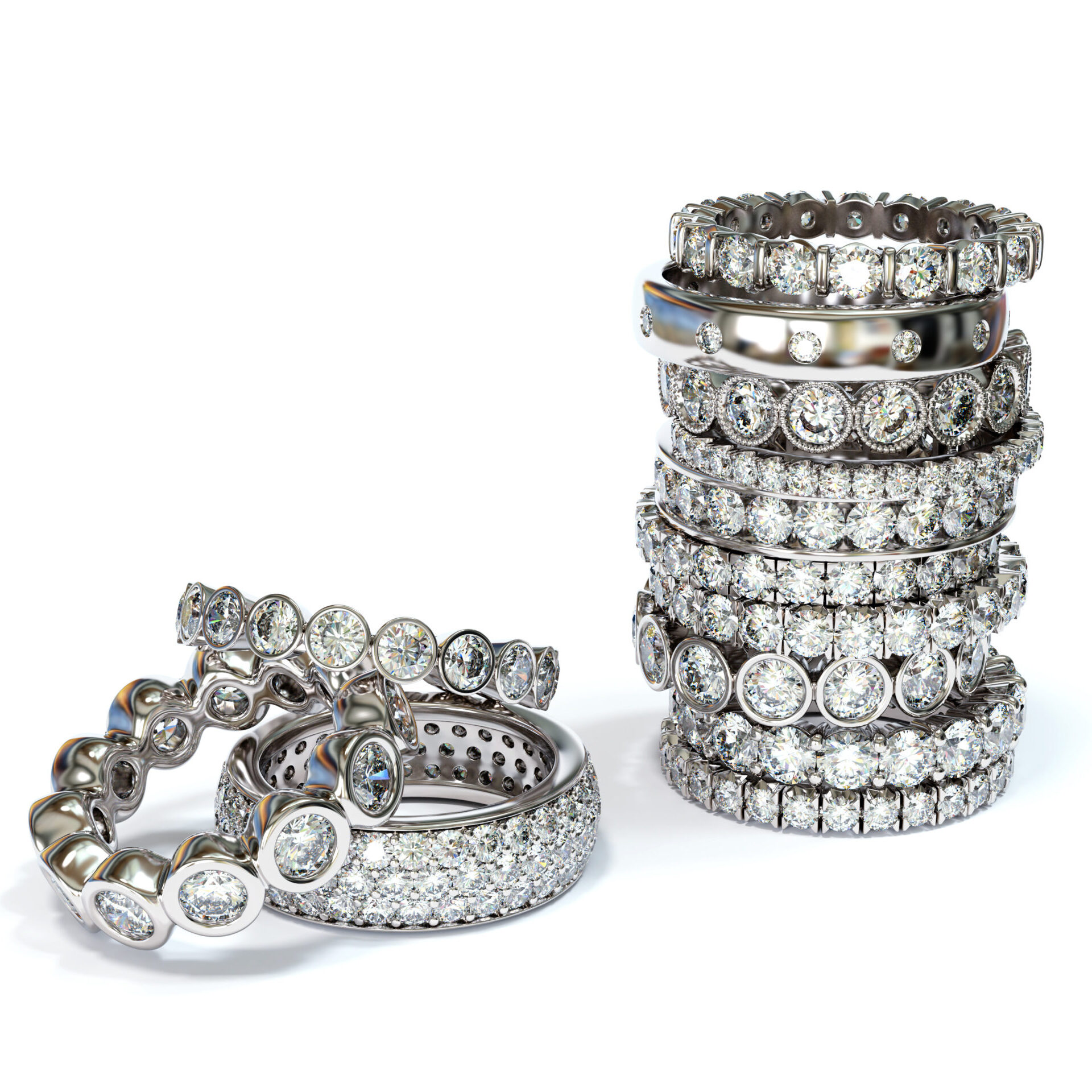 Pile of variously set diamond eternity rings on white background