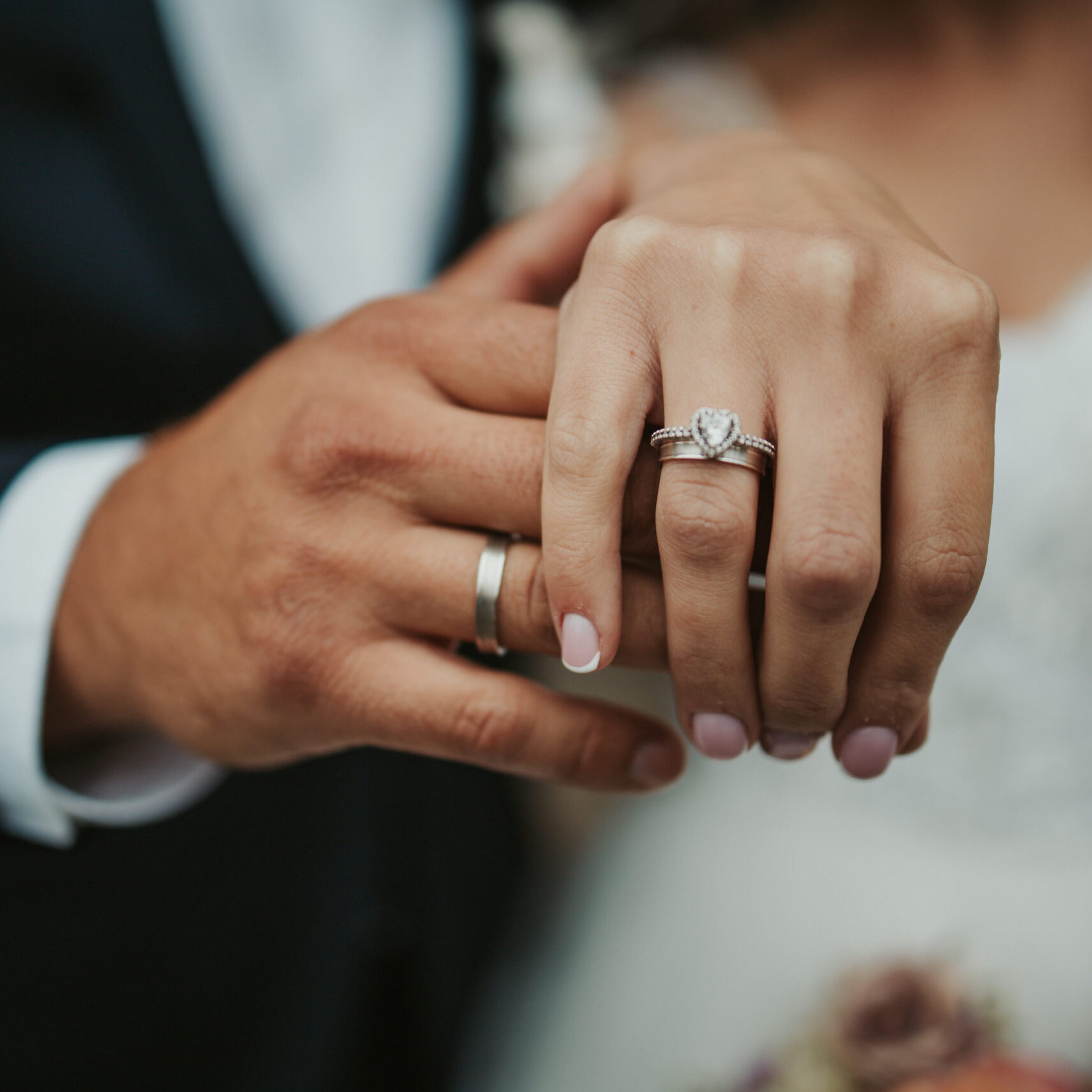 Beautiful shot of the hands of a bride and groom showing their rings – wedding, anniversary